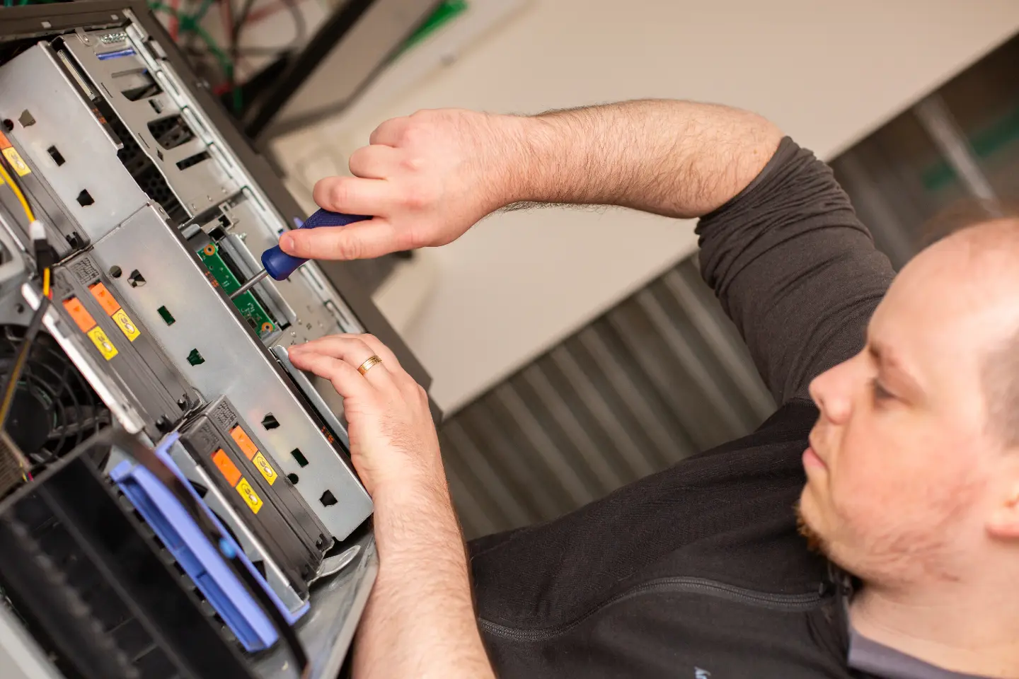 Teamwork team member fixing a server with a screwdriver