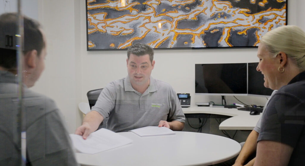 James Borg, the founder of Teamwork Technology, talking to two people in an office.