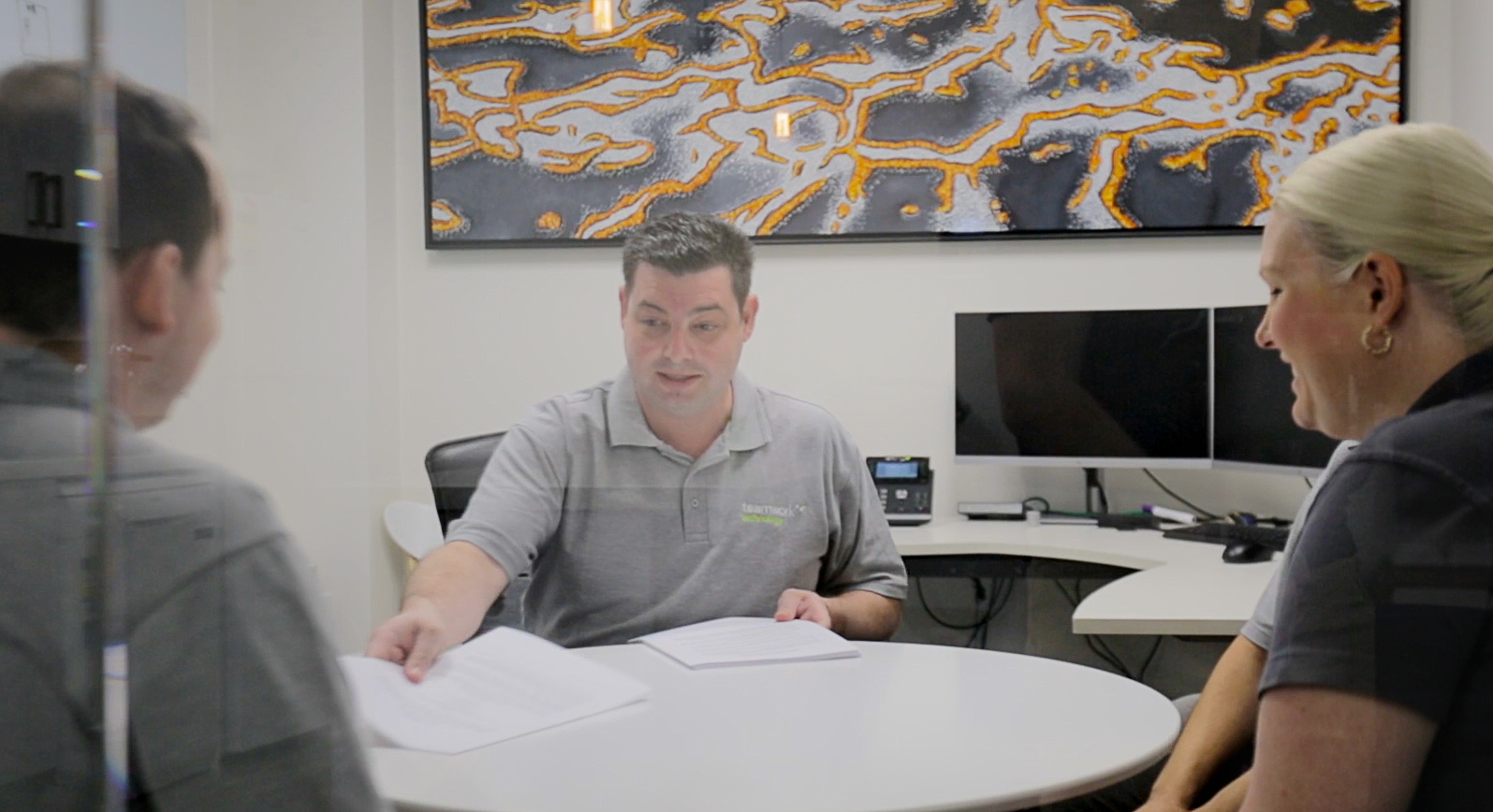 James Borg, the founder of Teamwork Technology, talking to two people in an office.
